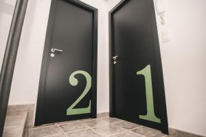 une paire de portes noires portant des numéros verts dans l'établissement Secret Spot Hostel, à La Massana