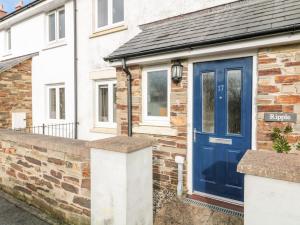 una casa in mattoni con una porta blu di Ripple a Bodmin