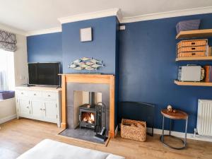 a living room with a fireplace and a tv at Honeybees Haven in Hunstanton