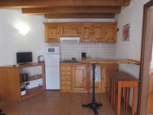 a kitchen with wooden cabinets and a white refrigerator at Private Apartments 1 minute to the pool & beach Santa Maria #74B #86 in Santa Maria