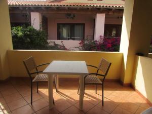 une table et des chaises sur un balcon avec une maison dans l'établissement Private Apartments 1 minute to the pool & beach Santa Maria #74B #86, à Santa Maria