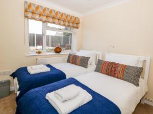 a bedroom with two beds and a window at Honeybees Haven in Hunstanton