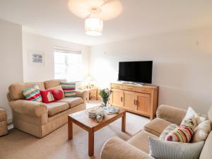 a living room with two couches and a flat screen tv at Ripple in Bodmin