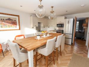 a kitchen and dining room with a wooden table and white chairs at 3 Eaton Mews in Chester