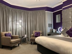 a hotel room with a bed and two chairs at The 25 Boutique B&B - Adults Only in Torquay