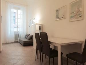 a dining room with a table and chairs and a couch at MistrangeloHome 5 - Appartamento in Pieno Centro in Savona