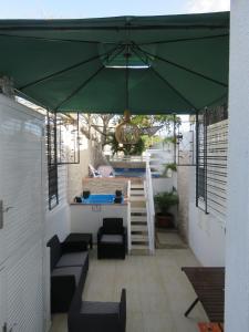 una sombrilla verde en un patio con mesa en Posada J&J Forbes - 1, en San Andrés