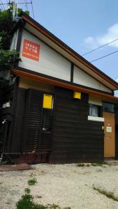 un bâtiment avec un panneau sur son côté dans l'établissement HAKUBA IKEDA LIFE KAN APARTMENTS, à Hakuba