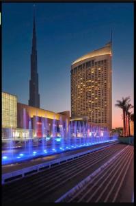 杜拜的住宿－Address Dubai Mall Residences New name EMAAR Residences Fashion Avenue 1 bedroom 34 floor，前面有蓝色灯的大建筑