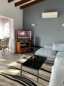 ein Wohnzimmer mit einem Sofa und einem TV in der Unterkunft Ca Liberty in Moraira