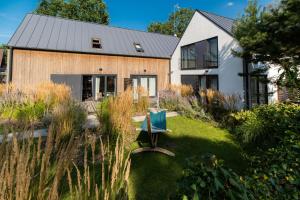 een huis met een bank in de tuin bij Skandynawskie Domy in Pobierowo