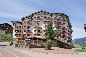 a large building with a tree in front of it at Résidence Pierre & Vacances Le Britania in La Tania