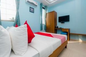 a bedroom with a bed with red and white pillows at HOTEL SHIVRAI in Pen