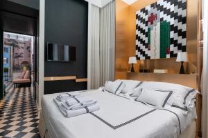 a bedroom with a large white bed and a checkered floor at Pantheon Balcony Morgana Suite in Rome