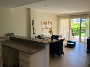 cocina con encimera y sala de estar. en Beautiful One Bedroom unit with pool and Beach club in a Golf Project, en Punta Cana