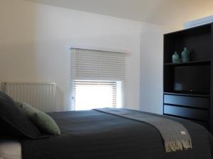 a bedroom with a bed with a television and a window at De Ruttermolen in Tongeren