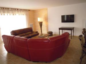 a living room with a red couch and a table at LES MARMOTTES in Gez