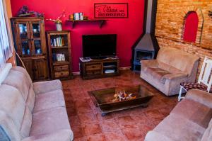 sala de estar con 2 sofás y chimenea en La Casa del Herrero, en El Poyo