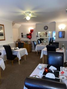 a dining room with white tables and chairs and a restaurant at Crowndale Torquay - Exclusively for Adults in Torquay
