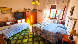 a bedroom with two beds and a flat screen tv at Bed and breakfast Giuseppina in Rome