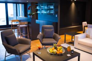 a lobby with chairs and a table with a bowl of fruit at Radisson Hotel Dakar Diamniadio in Dakar