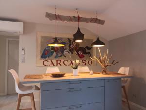 a kitchen with a blue island with two lights at Gîte Carcasso in Carcassonne
