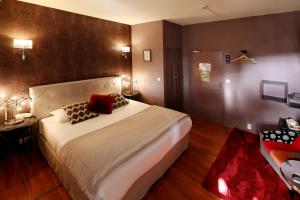 a bedroom with a large white bed with two pillows at Charming Hôtel - Les Pasteliers in Albi