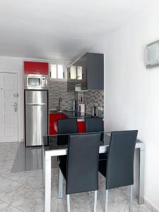 a kitchen with a table with chairs and a refrigerator at Apartment El Dorado, Las Americas in Arona