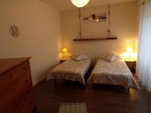 een slaapkamer met 2 bedden, 2 lampen en een dressoir bij Gite La Méluzine in Magny
