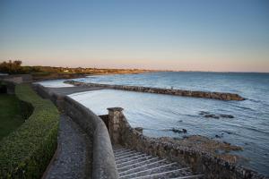 a view of a body of water with a stone wall at La Posta Vecchia Hotel in Ladispoli