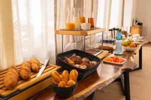 einen Frühstückstisch mit Brot und Gebäck darauf in der Unterkunft Hotel L'Adresse Dakar in Dakar