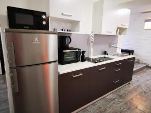 a kitchen with a stainless steel refrigerator and a microwave at Luxury Basement in the surrounding of Budapest in Mogyoród