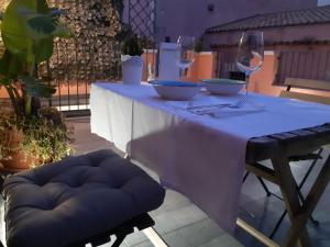einen Tisch mit einem lila Tischtuch und zwei Weingläsern in der Unterkunft Galena Charme Luxury Terrace in Syrakus