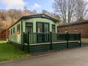 a green tiny house on the side of a street at Calgarth Lodge in Windermere