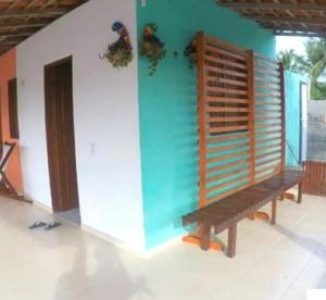 eine Holzbank in einem Zimmer mit einer Wand in der Unterkunft Pousada Flor do deserto - Mandacaru in Santo Amaro
