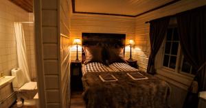 a bedroom with a bed and two lamps and a sink at Skarvruets Högfjällshotell in Tänndalen