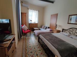 a hotel room with two beds and a television at Ellas Place in Tarxien