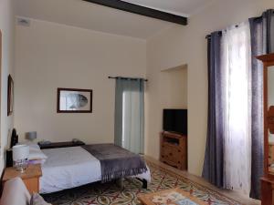 sypialnia z łóżkiem i telewizorem w obiekcie Ellas Place w mieście Tarxien