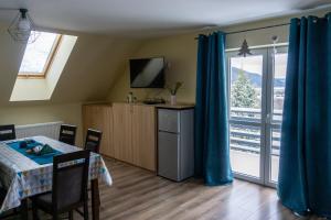 ein Esszimmer mit einem Tisch und einer Glasschiebetür in der Unterkunft Pokoje Gościnne 4 Pory Roku in Klimkówka