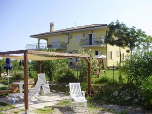 a group of chairs and an umbrella in front of a house at Villa Marianna in Vasto