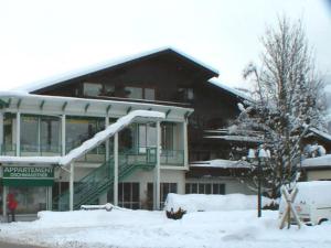 ein schneebedecktes Gebäude mit einer Treppe davor in der Unterkunft Appartement Gschwandtner in Zell am See