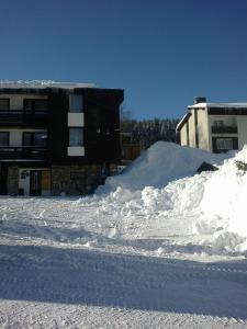 a pile of snow in front of a building at Ubytování v soukromí Kouba in Pec pod Sněžkou