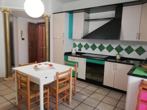 una cocina con mesa blanca y sillas. en Appartamento Tropea Dario, en Tropea