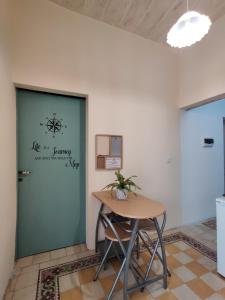 um quarto com uma mesa e uma porta verde em Rons Town House em Tarxien
