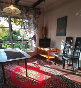 ein Wohnzimmer mit Stühlen, einem Tisch und einem Fenster in der Unterkunft Kelluka Holiday House in Pärispea