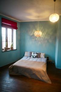 een slaapkamer met een bed met blauwe muren en 2 verlichting bij Sunrise Apartment in Kamjanets-Podilsky