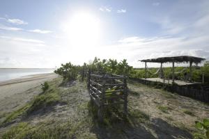 a fence on the beach next to the water at Refugios Parajuru - Villa Alegre in Parajuru