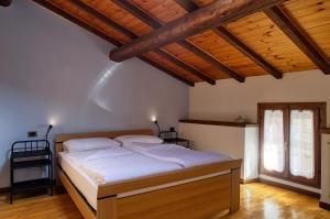 a bedroom with a bed in a room with wooden ceilings at Casa Dany in Malcesine