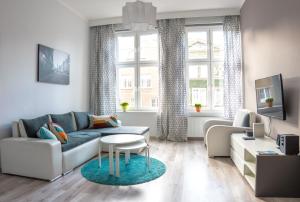 a living room with a couch and a table at Long Street Apartment in Gdańsk