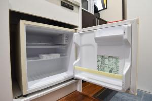 an empty refrigerator with its door open in a kitchen at ティーダの森 （TIDA NO MORI） in Agarii
